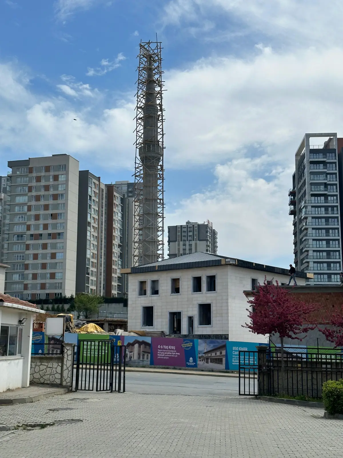 Sokaktan genel görünüm — minare, cami ve çevre bloklar