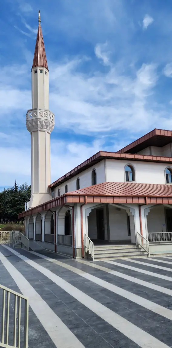 Avludan görünüm — revak sırası, giriş merdivenleri ve tek şerefeli minare
