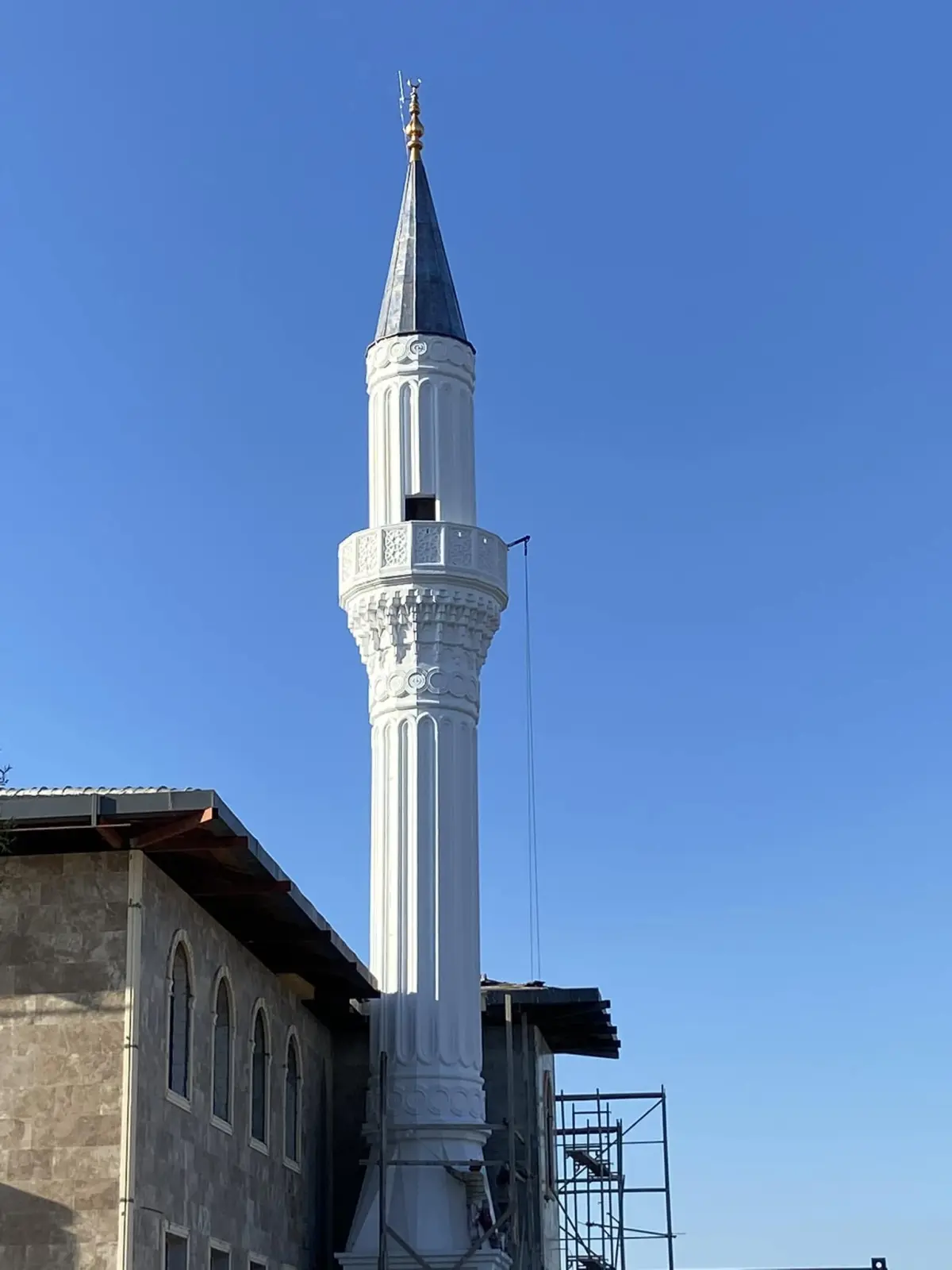 Eston Şehir Camii minaresi — yivli beyaz gövde ve koyu külah