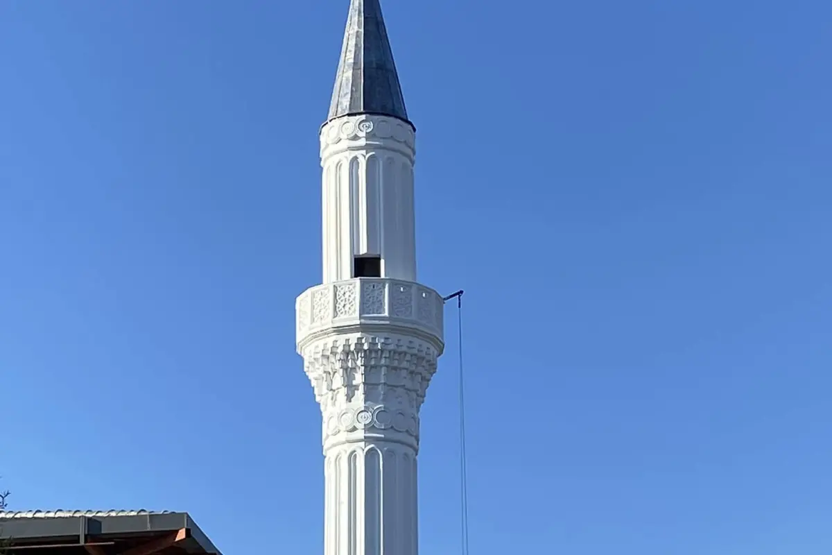 Eston Şehir Camii minaresi — yivli beyaz gövde ve koyu külah