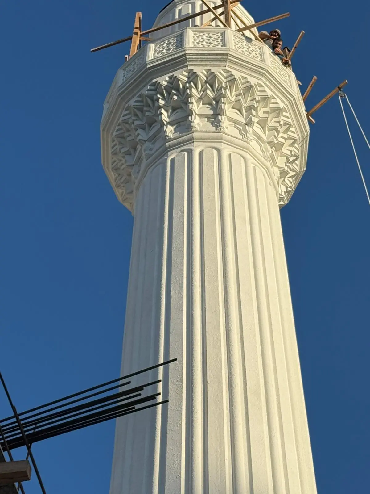 Şerefe altındaki mukarnas sıraları, ahşap iskele arasından
