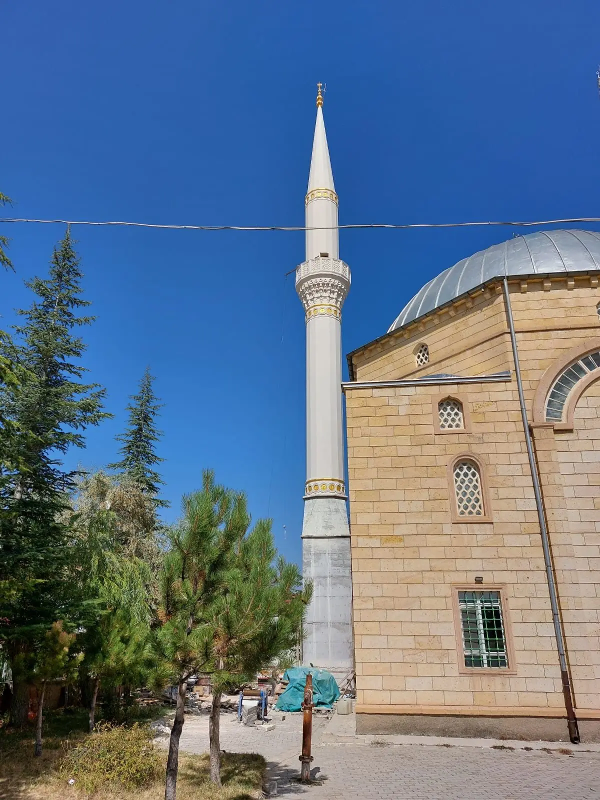 Niğde Karatlı Camii — kesme taş cephe, kubbe ve beyaz minare