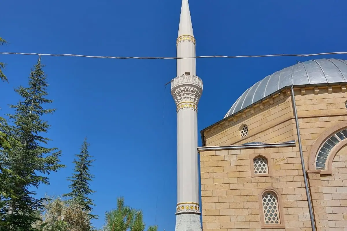 Niğde Karatlı Camii — kesme taş cephe, kubbe ve beyaz minare